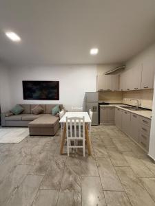 a kitchen and living room with a table and a couch at Bejart Apartment 7 in Tirana