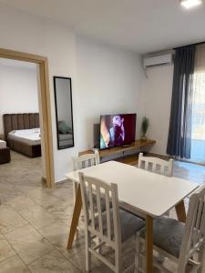 a living room with a table and a tv at Bejart Apartment 7 in Tirana