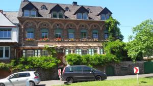 zwei Autos vor einem Gebäude geparkt in der Unterkunft Gästehaus zum Moseltal in Ellenz-Poltersdorf