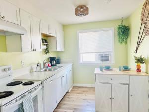 a kitchen with white cabinets and a sink and a window at Los Dos- Talavera and Sandia in Salem