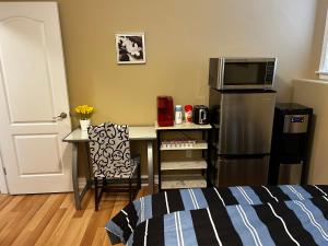 a room with a desk with a microwave and a refrigerator at Vito Place in Halifax