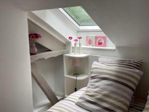 a bedroom with a bed with a skylight and a window at Cottage in Central Bayeux in Bayeux