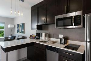 a kitchen with black cabinets and a microwave at Residence Inn by Marriott Atlanta Peachtree City in Peachtree City +3 photos