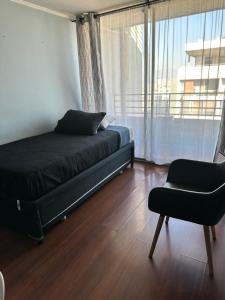a bedroom with a bed and a chair and a window at Never Give Up Suites in Santiago +12 photos