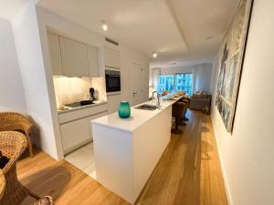 a kitchen with white cabinets and a green vase on a counter at Brussels City Apartment in Brussels