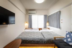 a bedroom with a bed and a tv and a couch at 泉音屋 in Fukuoka