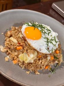 a plate of food with an egg on top of rice at Merta House Sidemen in Sidemen