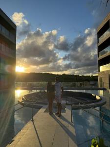 un homme et une femme debout au sommet d'un immeuble dans l'établissement Gav Porto Alto Resorts Porto de Galinhas, Pernambuco, à Penedo