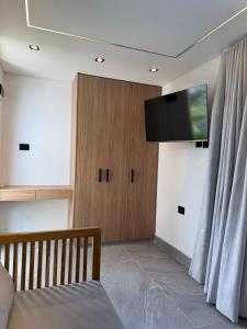 a room with a tv on the wall and a couch at Luxury Suite frente de Mar Piscina Restaurante y Bar in San Silvestre