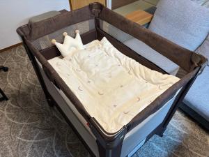 ein Babybett mit Matratze in einem Zimmer in der Unterkunft Takaoka House in Nagoya
