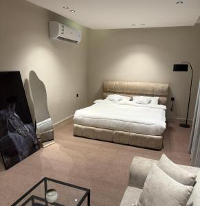 a bedroom with a large bed and a couch at استديو الهدوء in Dammam