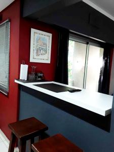 - une cuisine avec des murs rouges et un comptoir blanc dans l'établissement Cómodo y moderno departamento con cochera, a pasos de la principal calle comercial de la ciudad, à La Plata