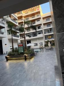 a large apartment building with a courtyard with palm trees at Studio in M'océan in Mohammedia