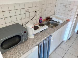 a microwave sitting on a counter next to a sink at Apartment with Balcony, Neuss in Neuss