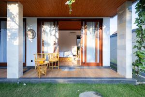 a patio with a table and chairs on a house at Cabaña de piña dulce ubud in Ubud