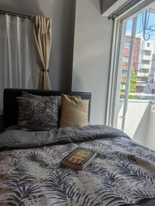 a book on top of a bed with a window at Sakura Fan 2F in Tokyo