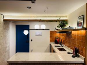 a kitchen with two sinks and a blue door at Urban Studio in the historic center of São Paulo in Sao Paulo +80 photos