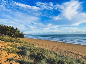 a person walking on a beach with the ocean at 1770 Beachside Backpacker & Motel in Agnes Water