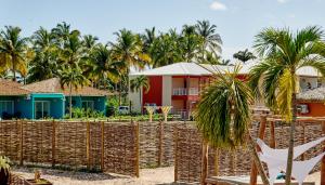 a resort with a fence and palm trees at SWEET HOME plage privée in Folle Anse