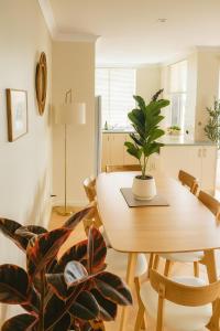 a dining room with a table and a potted plant at Waterfront bliss, spacious corner block in Mandurah