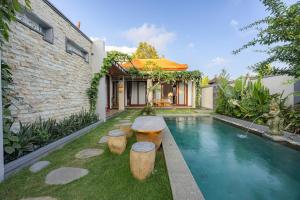a backyard with a swimming pool and a house at Cabaña de piña dulce ubud in Ubud