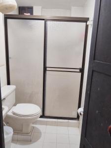 a bathroom with a toilet and a glass shower door at Apartamento Edificio Mara Rodadero in Rodadero +12 photos