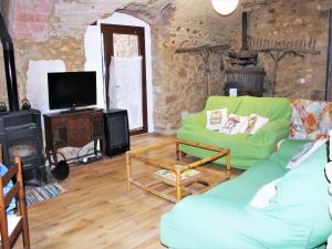 a living room with a green couch and a tv at Holiday Home in Catalonia near Cala Pedrosa Beach in Girona