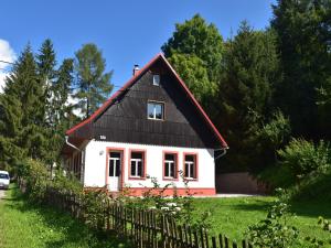 a small white house with a black roof at Holiday Home Rudník near Ski Lift in Javorník