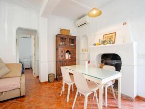 ein Wohnzimmer mit Tisch und Stühlen und einem Kamin in der Unterkunft Holiday Home in La Cala de Mijas by the Beach in La Cala de Mijas + 32 Fotos