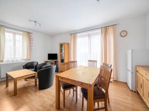 un soggiorno con tavolo, sedie e divano di Lakeside Lipno Holiday Stay a Lipno nad Vltavou