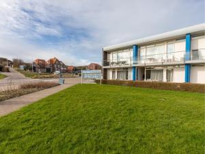 a building with a green lawn in front of it at Zoutelande Retreat by Sea in Zoutelande