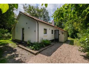 a small white house with a door in a yard at Holiday Home in Dishoek near Beach & Dunes in Dishoek