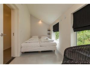 a bedroom with two beds and a window at Holiday Home in Dishoek near Beach & Dunes in Dishoek