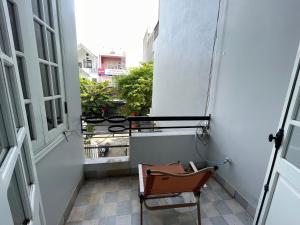 a chair on a balcony with a view of a street at Cozy Dormitory House in Da Nang +3 photos