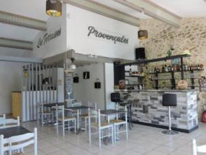 a restaurant with tables and chairs and a bar at Mobil-home confortable avec terrasse - 4 pers., 2 chambres - API-1-52-252 in Venterol