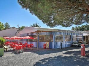 a restaurant with tables and chairs and umbrellas at Mobil-home 2 chambres avec terrasse - API-1-52-456 in La Mothe-Achard +10 photos