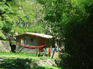 ein Haus mit einer Hängematte davor in der Unterkunft Chalet avec Terrasse et Salon de Jardin à Darbres - API-1-52-419 in Darbres
