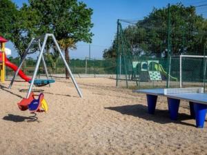 a playground with a table and a swing set at Mobil-home 2 Chambres avec Terrasse - API-1-52-407 in Brétignolles-sur-Mer