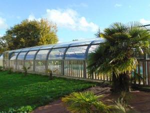 a palm tree in front of a building with a fence at Mobil home 5 pers à Avrillé avec terrasse - API-1-52-587 in Avrillé +3 photos