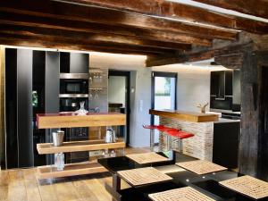 a kitchen with black and white appliances and red stools at Somptueuse villa Basque avec vue sur la Rhune et grand jardin - FR-1-239-1145 in Urrugne