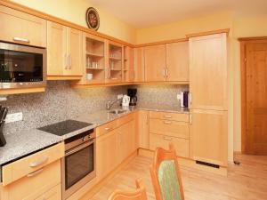 Chalet in Saalbach near Ski Lift & Sauna في سالباخ هينترغليم: مطبخ مع خزائن خشبية ومغسلة