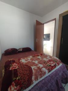 a bedroom with a bed with a blanket on it at Apartamento 2 quartos in Cascavel