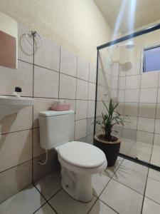 a white bathroom with a toilet and a sink at Apartamento 2 quartos in Cascavel +7 photos