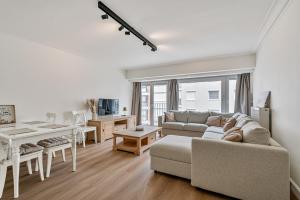 a living room with a couch and a table at Casa Améo in Ostend