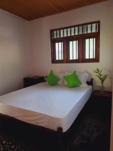 une chambre avec un grand lit avec des oreillers verts dans l'établissement KoKo HomeStay-Weligama Apartment & Private Room, à Walliwala East 27 autres photos