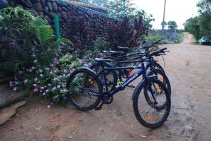 two bikes parked next to a wall with flowers at Vara Farm in Kanakapura