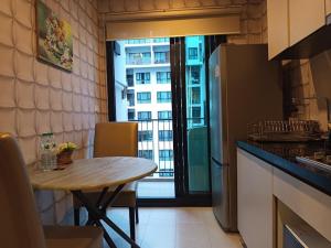 a kitchen with a small table and a kitchen with a window at Central Pattaya Apartment in Ban Chek +15 photos