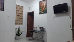 タバナンにあるThe Carik Homestayの壁にテレビが取り付けられたリビングルーム +12枚の写真