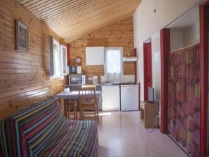 a room with a kitchen and a table in a room at Chalet avec Terrasse pour 4 personnes à Naucelle - API-1-52-380 in Naucelle