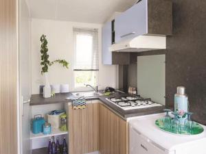 a kitchen with a sink and a stove top oven at Mobil-home cosy avec terrasse à Avrillé - API-1-52-490 in Avrillé
